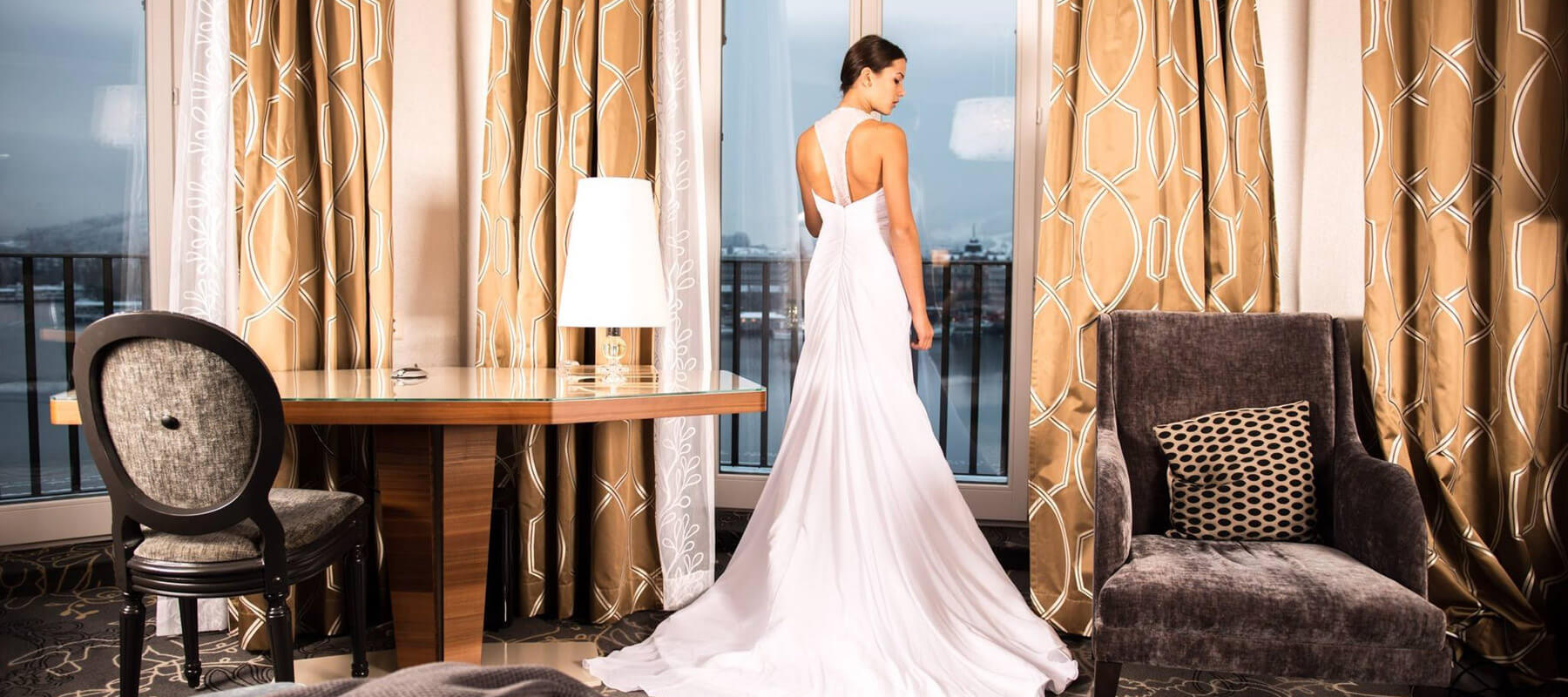 A bride wearing a long white wedding dress looking backwards